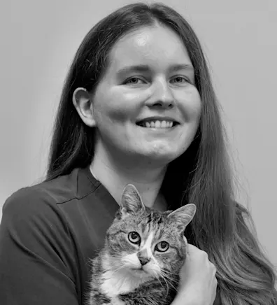 Nataliia holding onto a cat and smiling for a photo Nataliia holding onto a cat and smiling for a photo