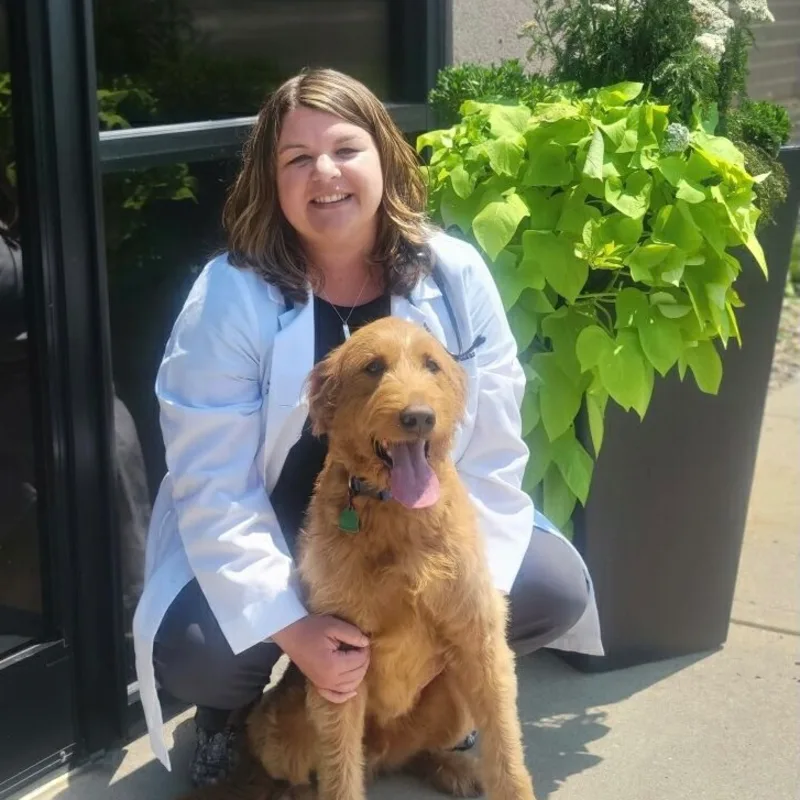 A veterinarian posing with dog A veterinarian posing with dog