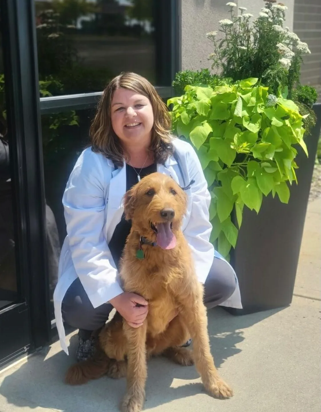 A veterinarian posing with dog A veterinarian posing with dog