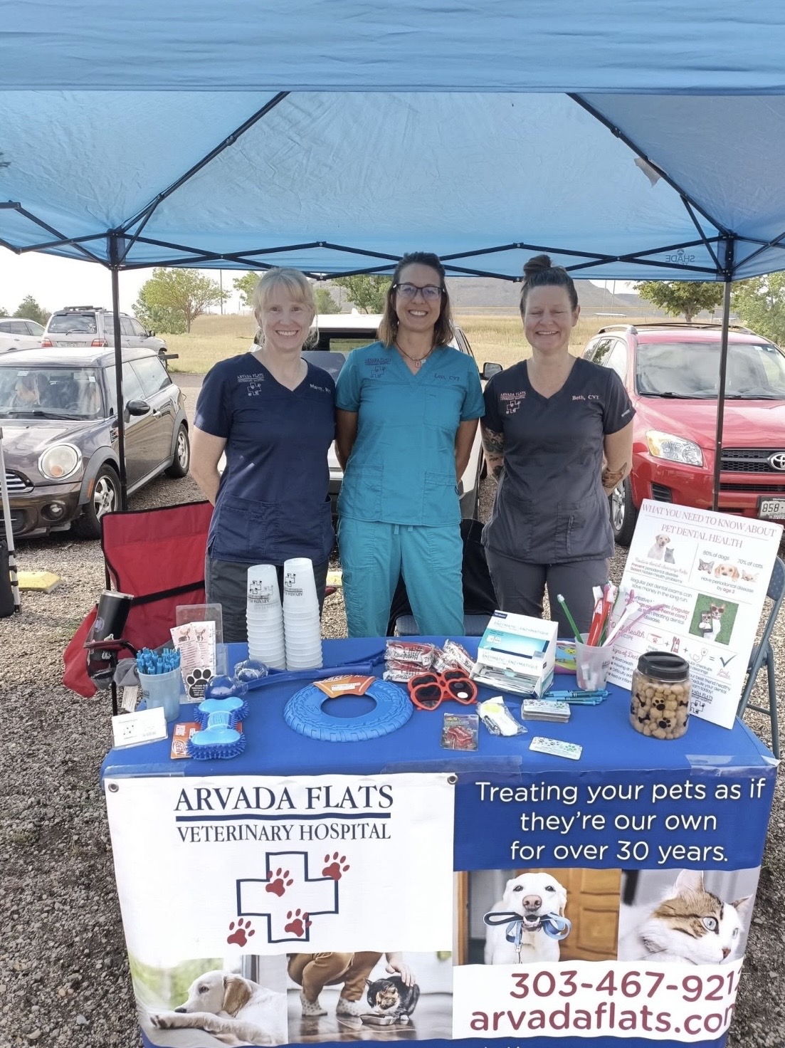 Three team members at the Arvada flats veterinary hospital event table