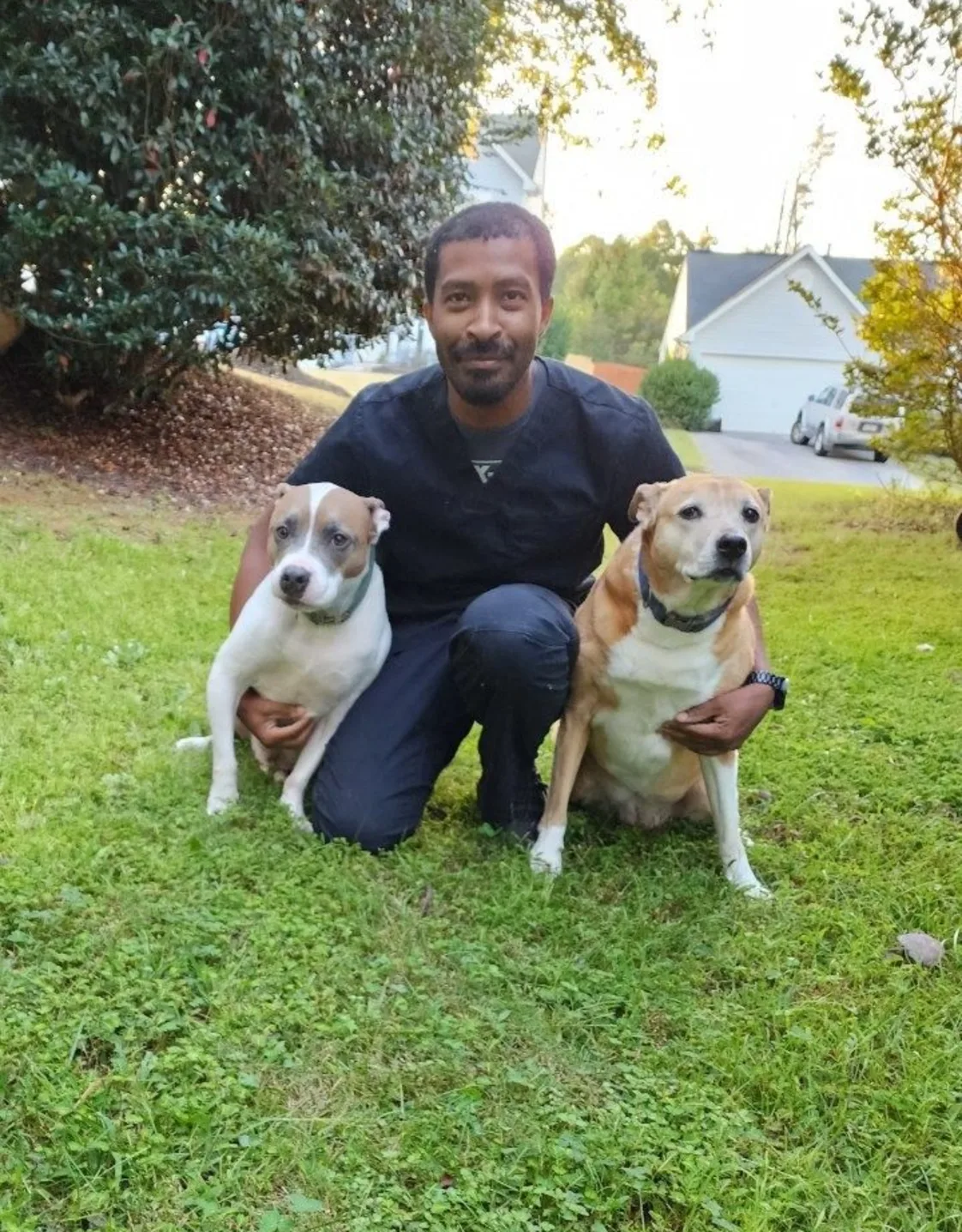 Jarrett sitting next to two dogs Jarrett sitting next to two dogs