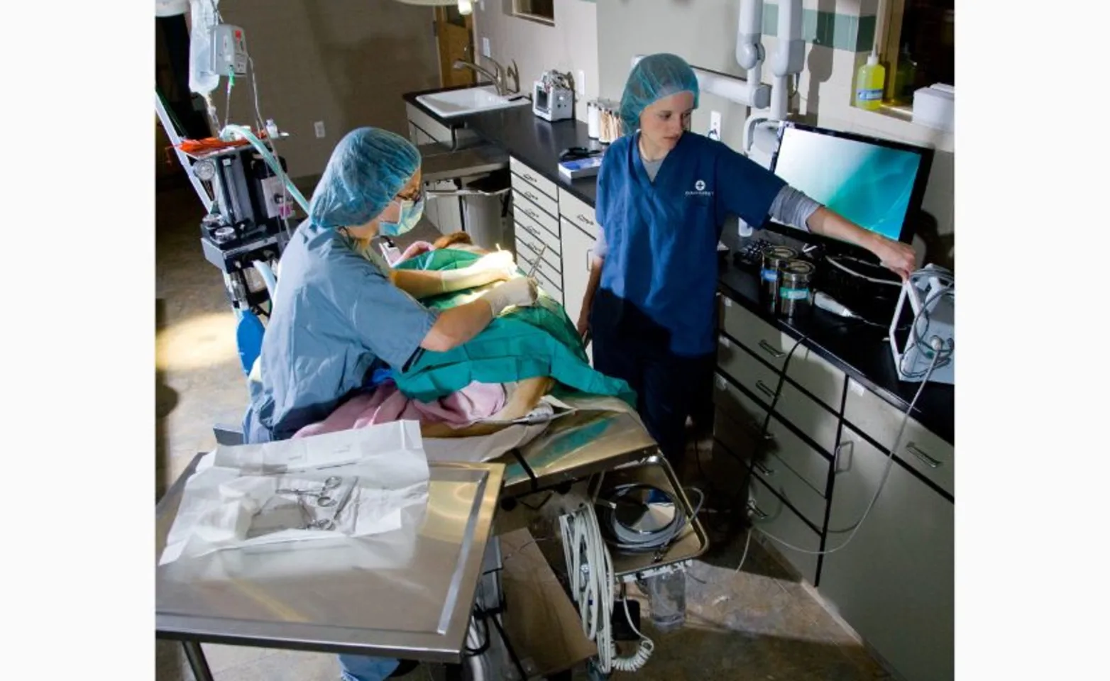 photo of doctors operating at table photo of doctors operating at table
