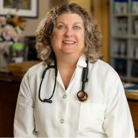 Dr. Nancy Vollmar holding a black and white cat.