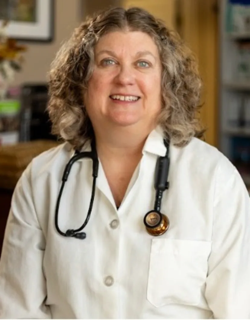 Dr. Nancy Vollmar holding a black and white cat.