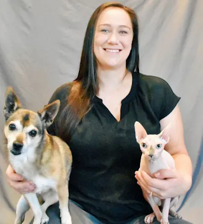 Dani sitting with a dog and a cat