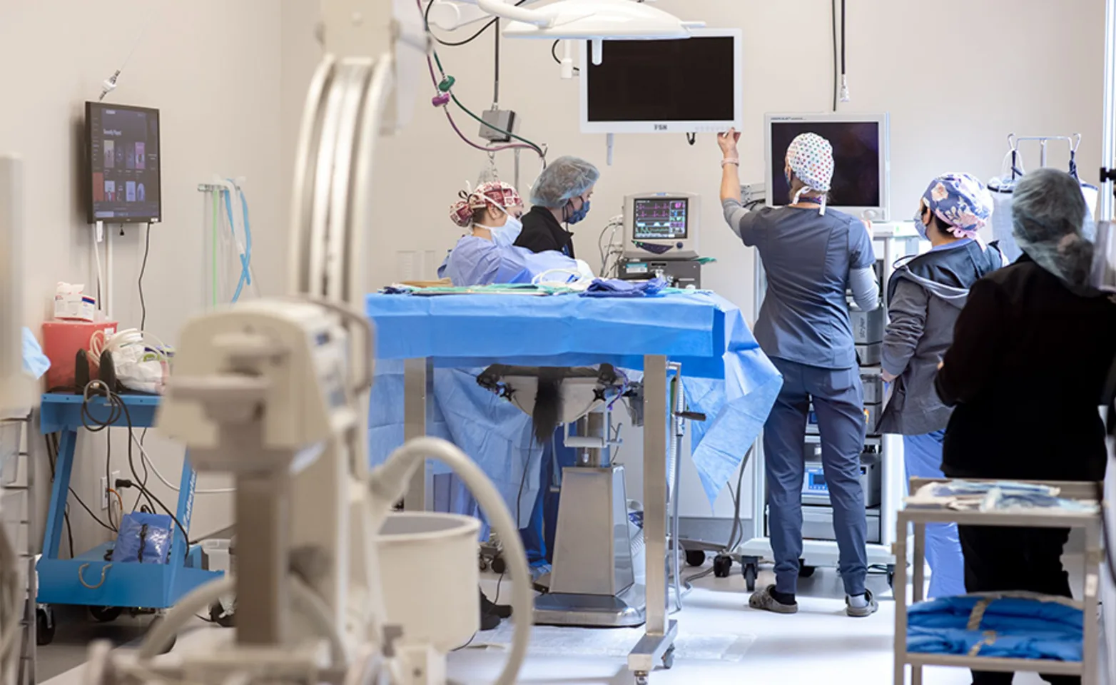 Technicians Preparing for Surgery with C-Arm in foreground