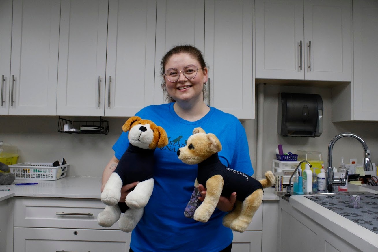 Staff member holding two stuffed animals.