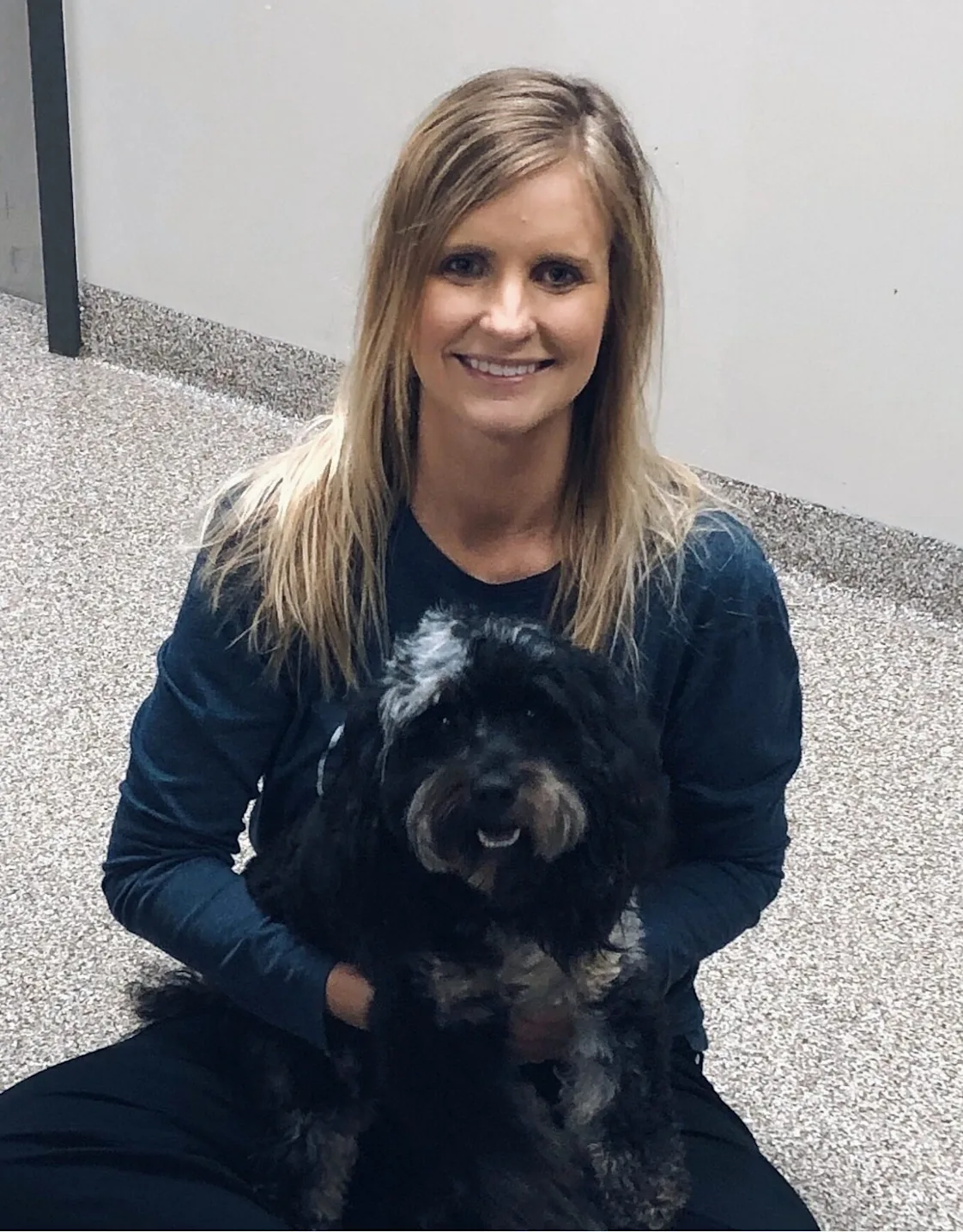 A veterinarian posing with a black dog A veterinarian posing with a black dog