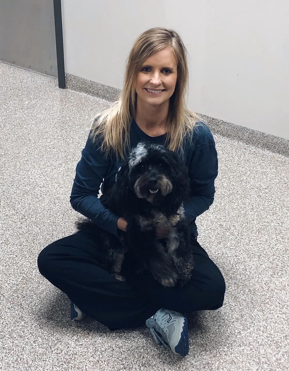 A veterinarian posing with a black dog A veterinarian posing with a black dog