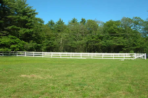 The facility includes four different size grass paddocks, one small sand turnout, a riding ring, a lunge area, and a deep sand round pen.