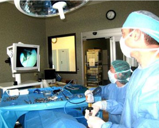 Surgeons looks at a screen during surgery.
