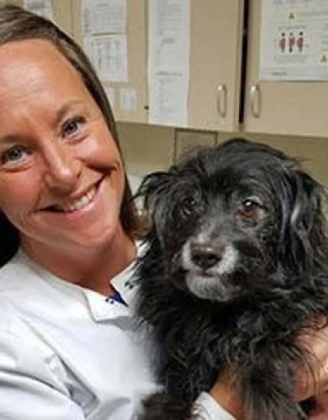 Kim - Veterinary Assistant holding a black scruffy dog at Animal Care Clinic West & Metro Cat Hospital Kim - Veterinary Assistant holding a black scruffy dog at Animal Care Clinic West & Metro Cat Hospital