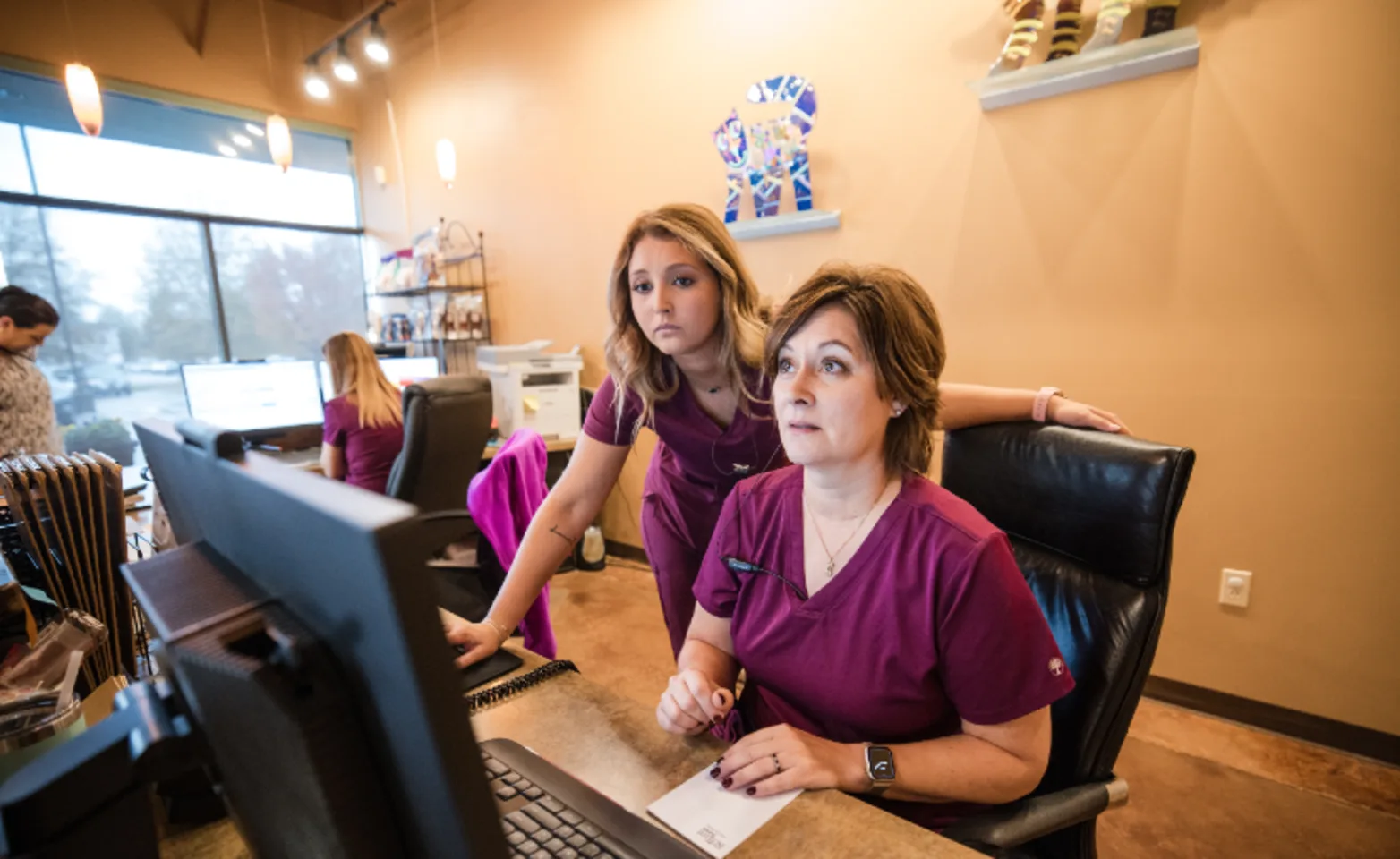 Two staff members looking at a computer screen Two staff members looking at a computer screen