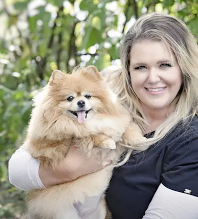 Brittney holding a gold and white fluffy Chihuahua