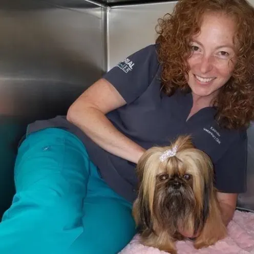 Heather, squeezed in a kennel with a small dog at Eastview Veterinary Clinic