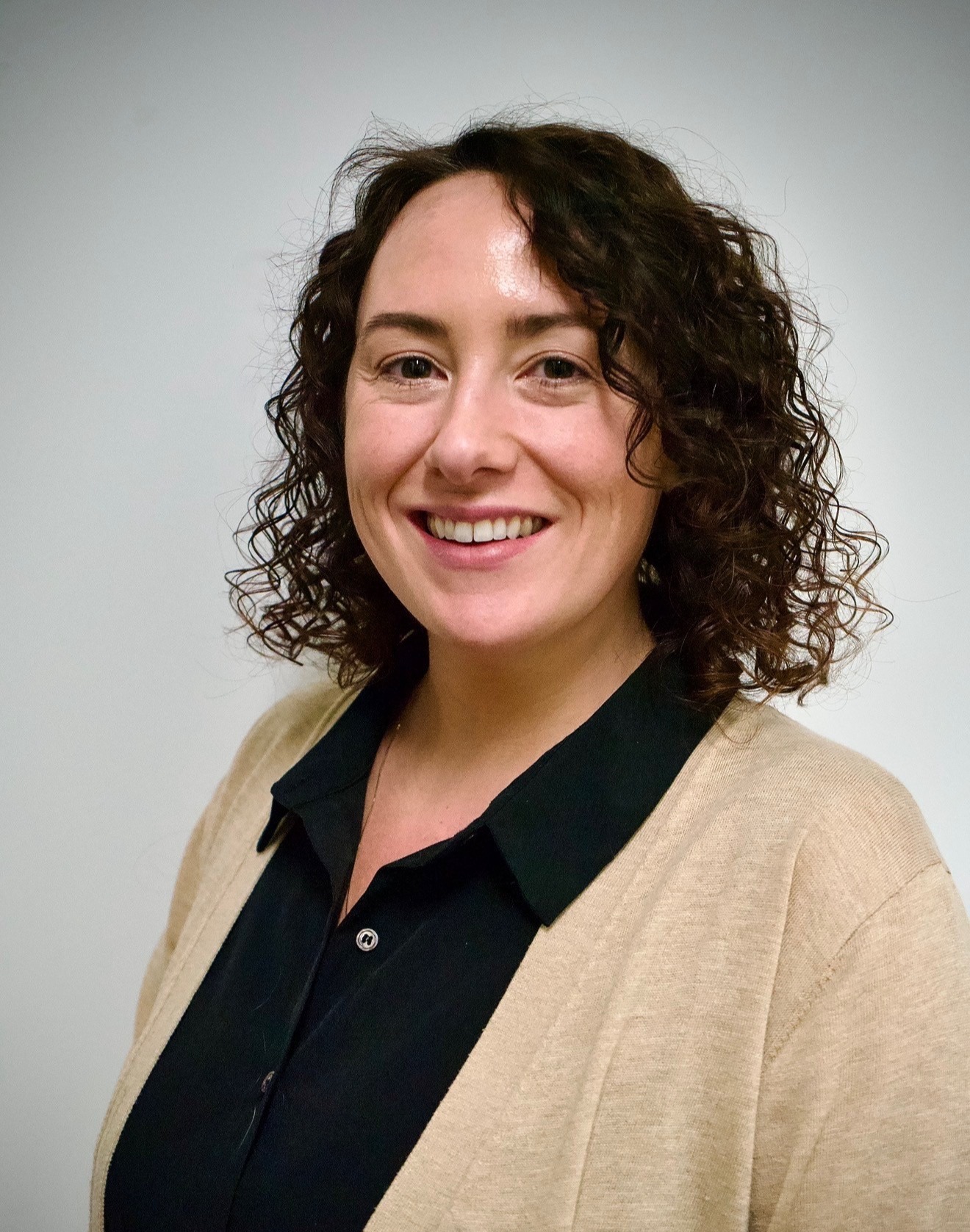 Dr Ashley Walker smiling at camera, wearing a white coat