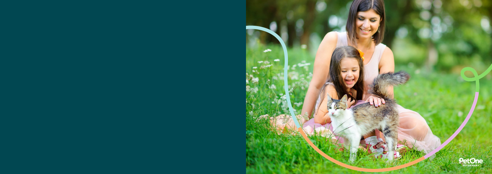 A woman and child sitting outside petting a cat in the grass.