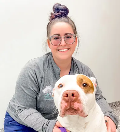 Mary Mullins smiling kneeling down next to a white and brown Pitbull Mary Mullins smiling kneeling down next to a white and brown Pitbull