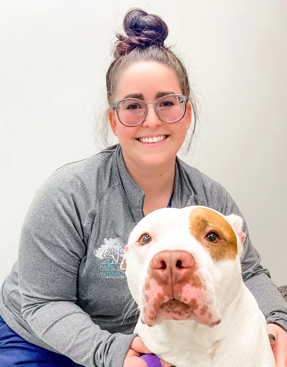 Mary Mullins smiling kneeling down next to a white and brown Pitbull Mary Mullins smiling kneeling down next to a white and brown Pitbull