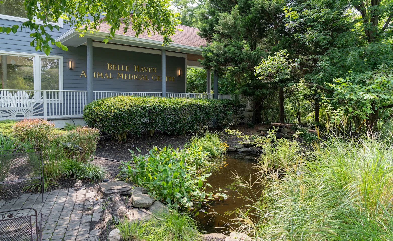 exterior of building with greenery and pond