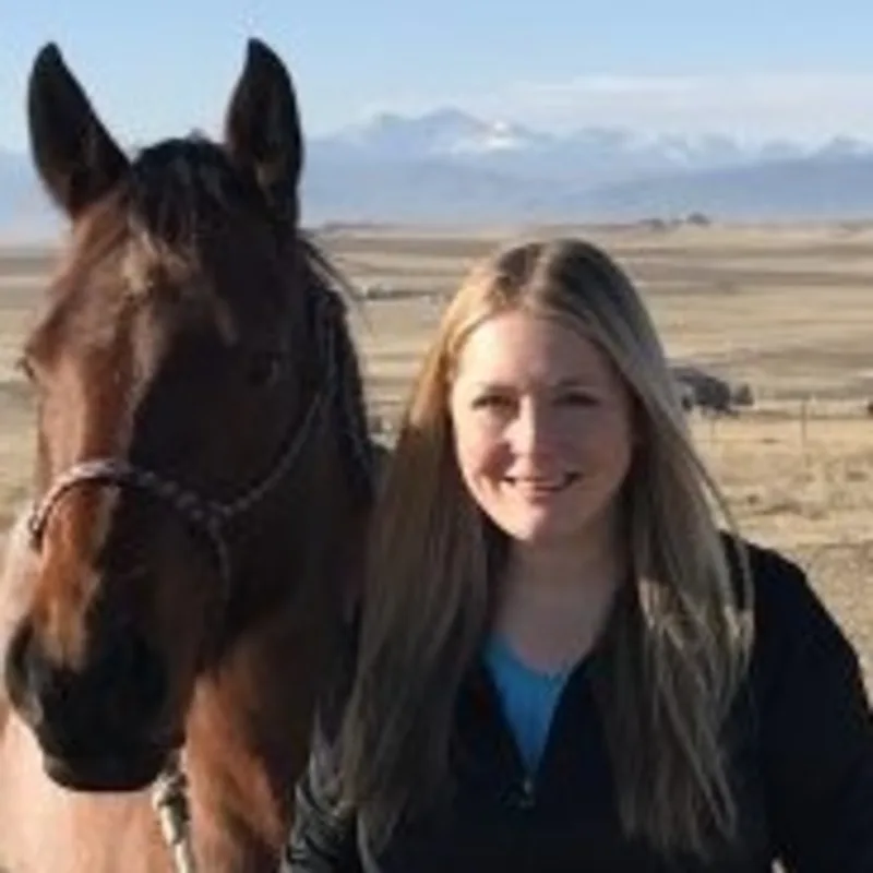 Dr. Jessica Wydallis standing outside with a brown horse Dr. Jessica Wydallis standing outside with a brown horse