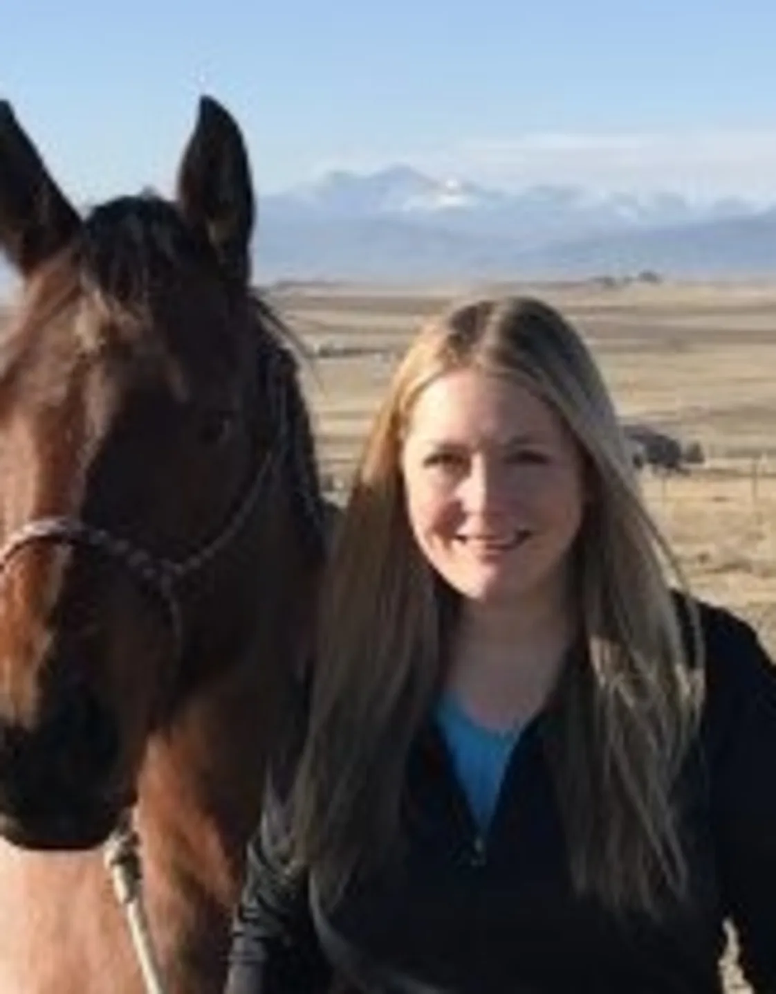 Dr. Jessica Wydallis standing outside with a brown horse Dr. Jessica Wydallis standing outside with a brown horse