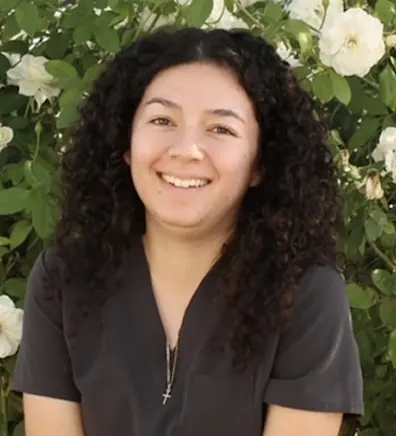 Woman with grey scrubs smiling at camera Woman with grey scrubs smiling at camera