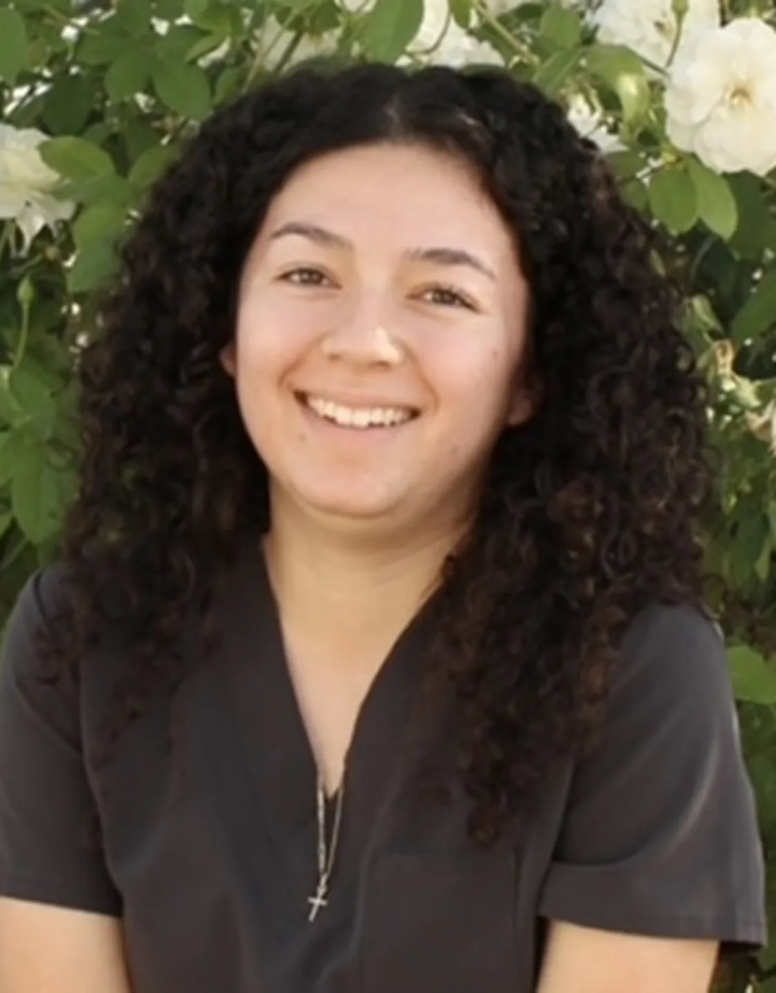 Woman with grey scrubs smiling at camera Woman with grey scrubs smiling at camera