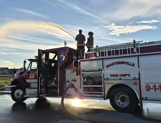 Firefighters standing on the top of a firetruck. Firefighters standing on the top of a firetruck.