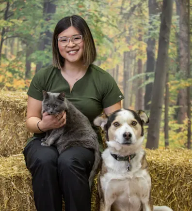 Joyce sitting with a dog and a cat