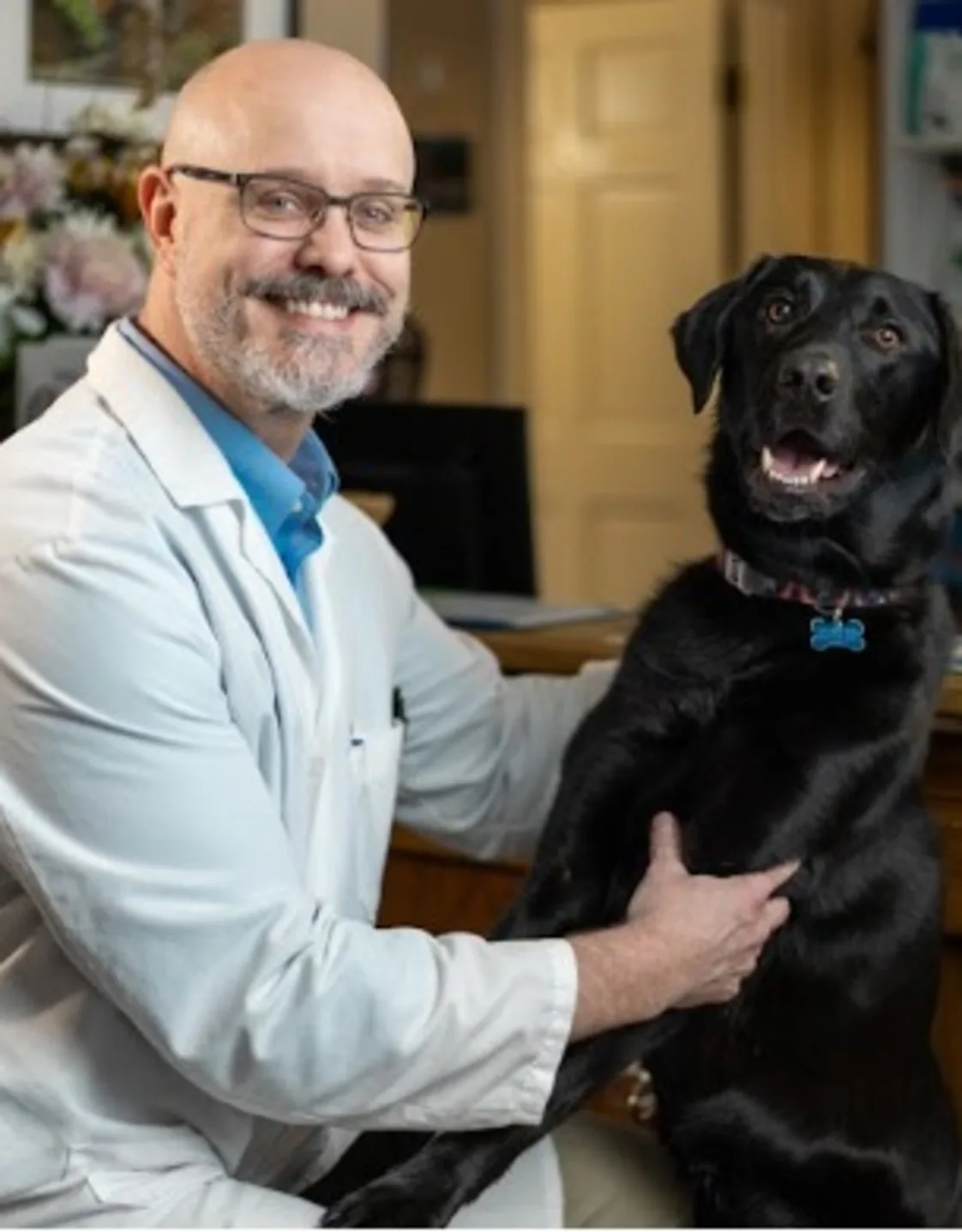 Dr. Anthony Brown holding a dog. Dr. Anthony Brown holding a dog.