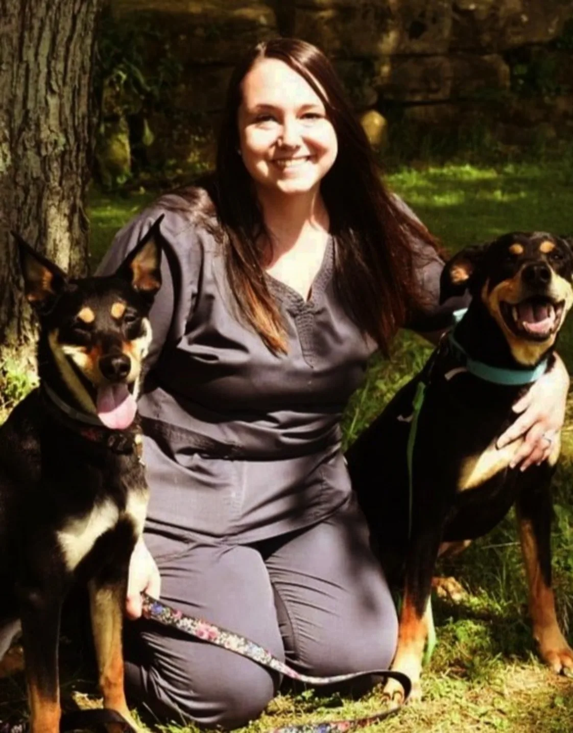 Amber kneeling on the grass next to two dogs Amber kneeling on the grass next to two dogs