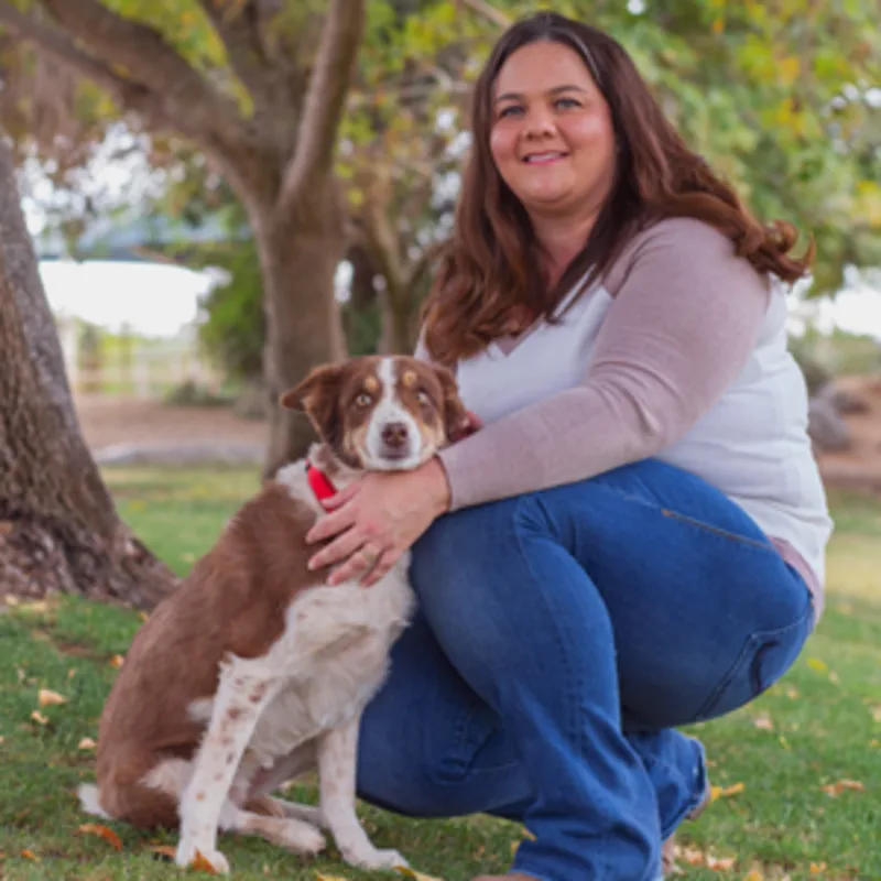 Nicolette Gamez kneeling next to a brown and white dog Nicolette Gamez kneeling next to a brown and white dog