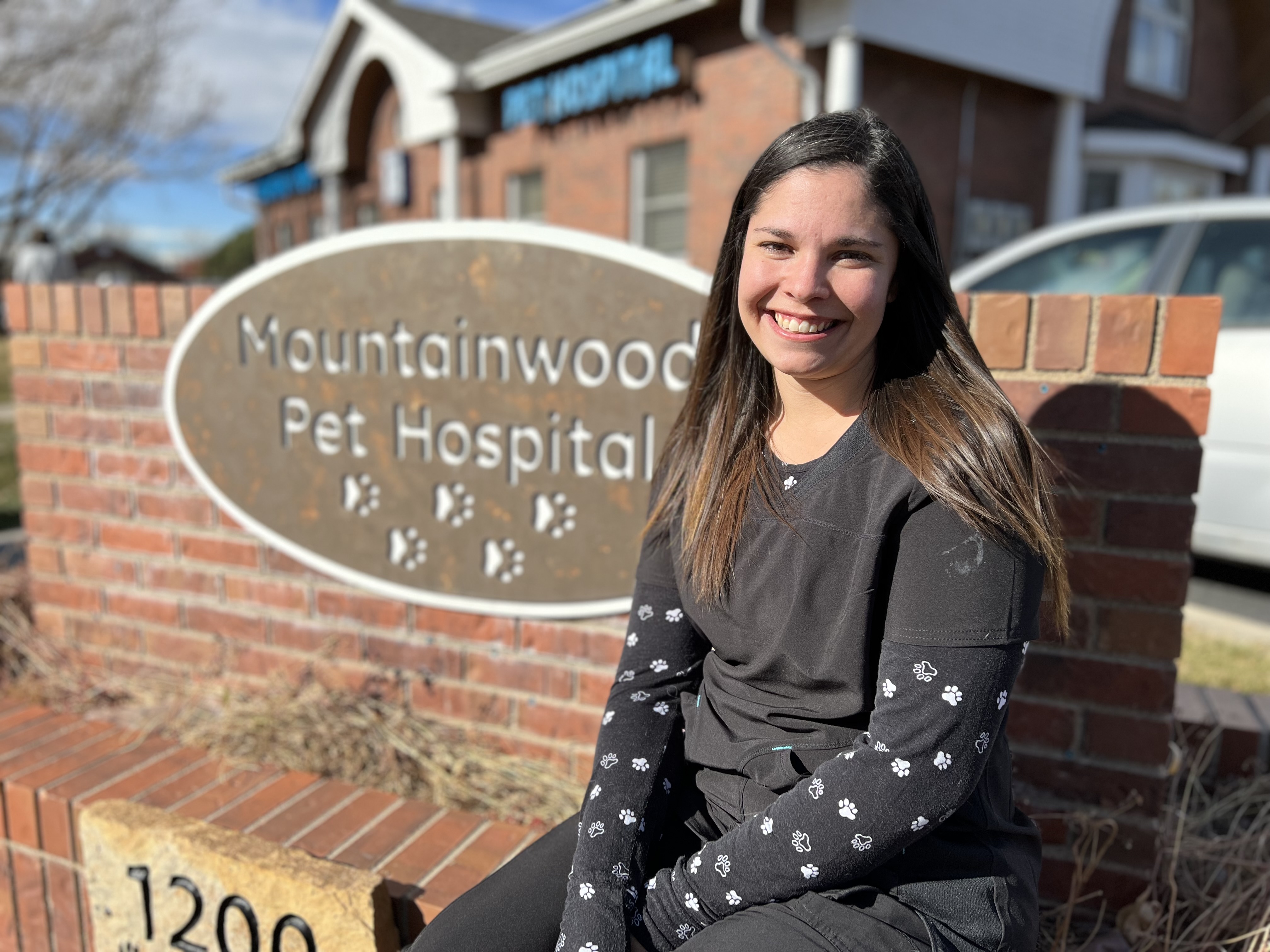 Tyra sitting next to the Mountainwood Pet Hospital sign