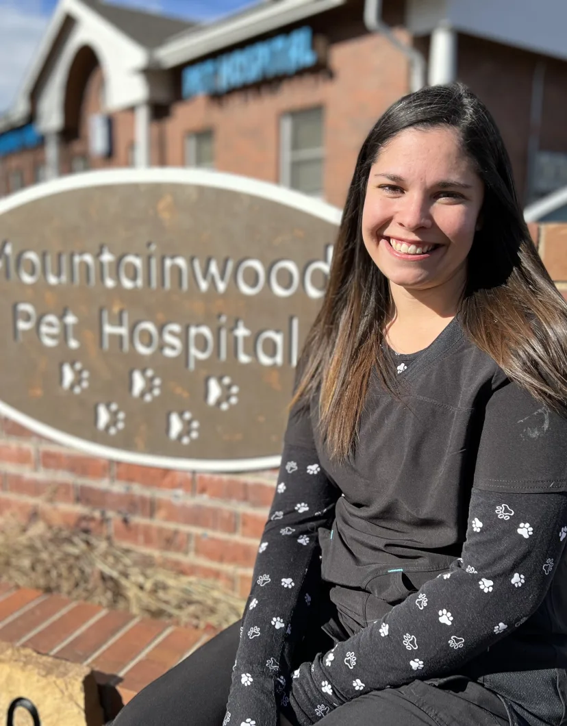Tyra sitting next to the Mountainwood Pet Hospital sign