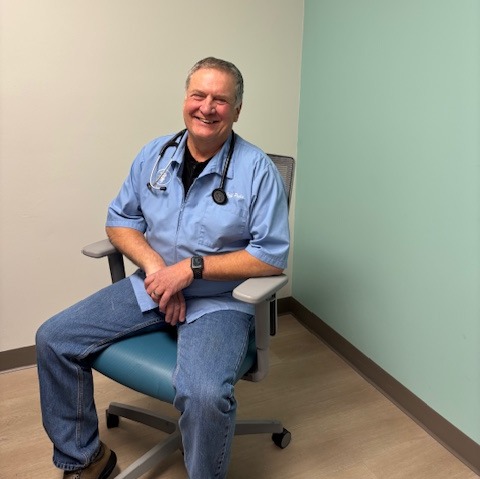 Dr Pelia holding fish in body of water