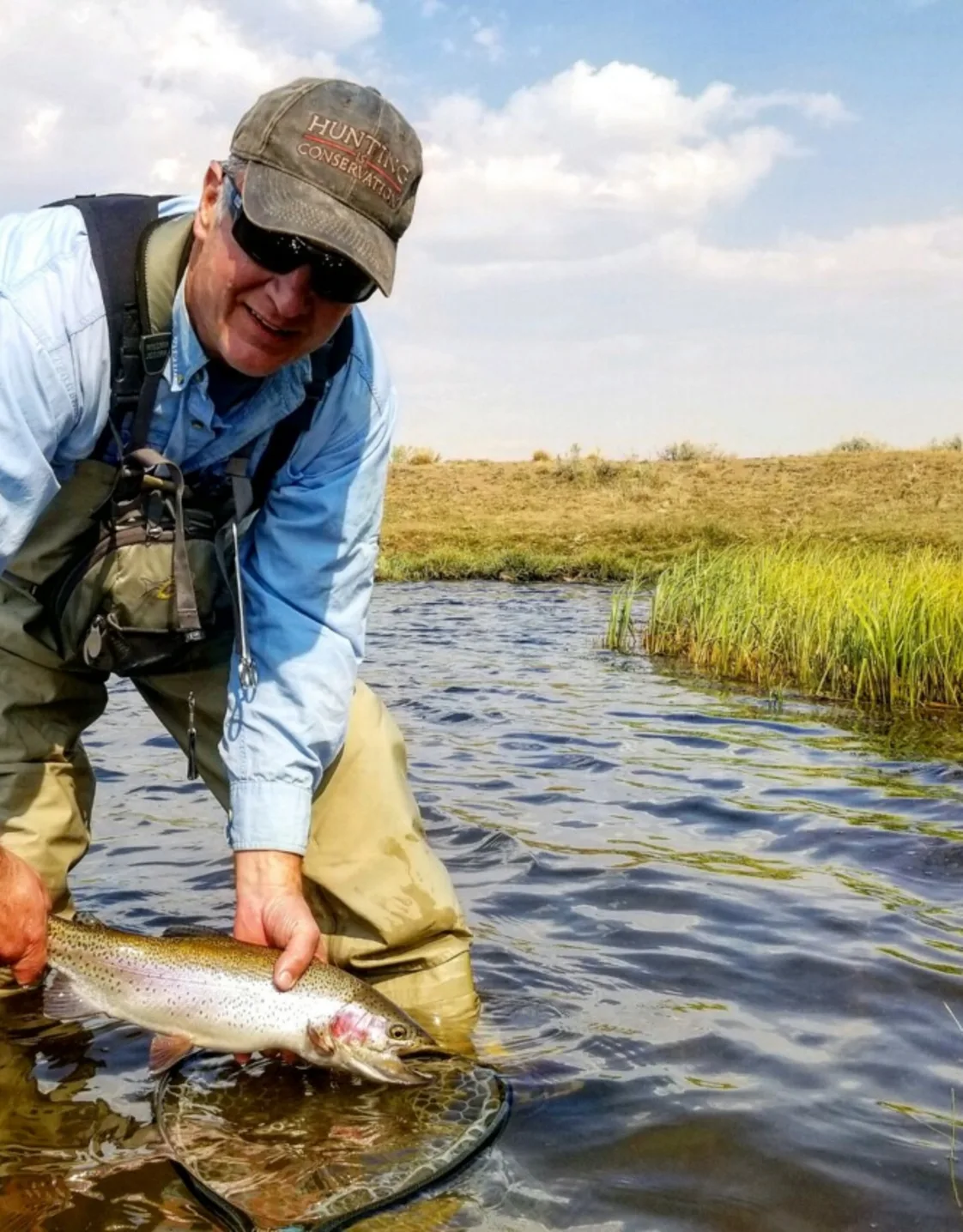Dr Pelia holding fish in body of water Dr Pelia holding fish in body of water