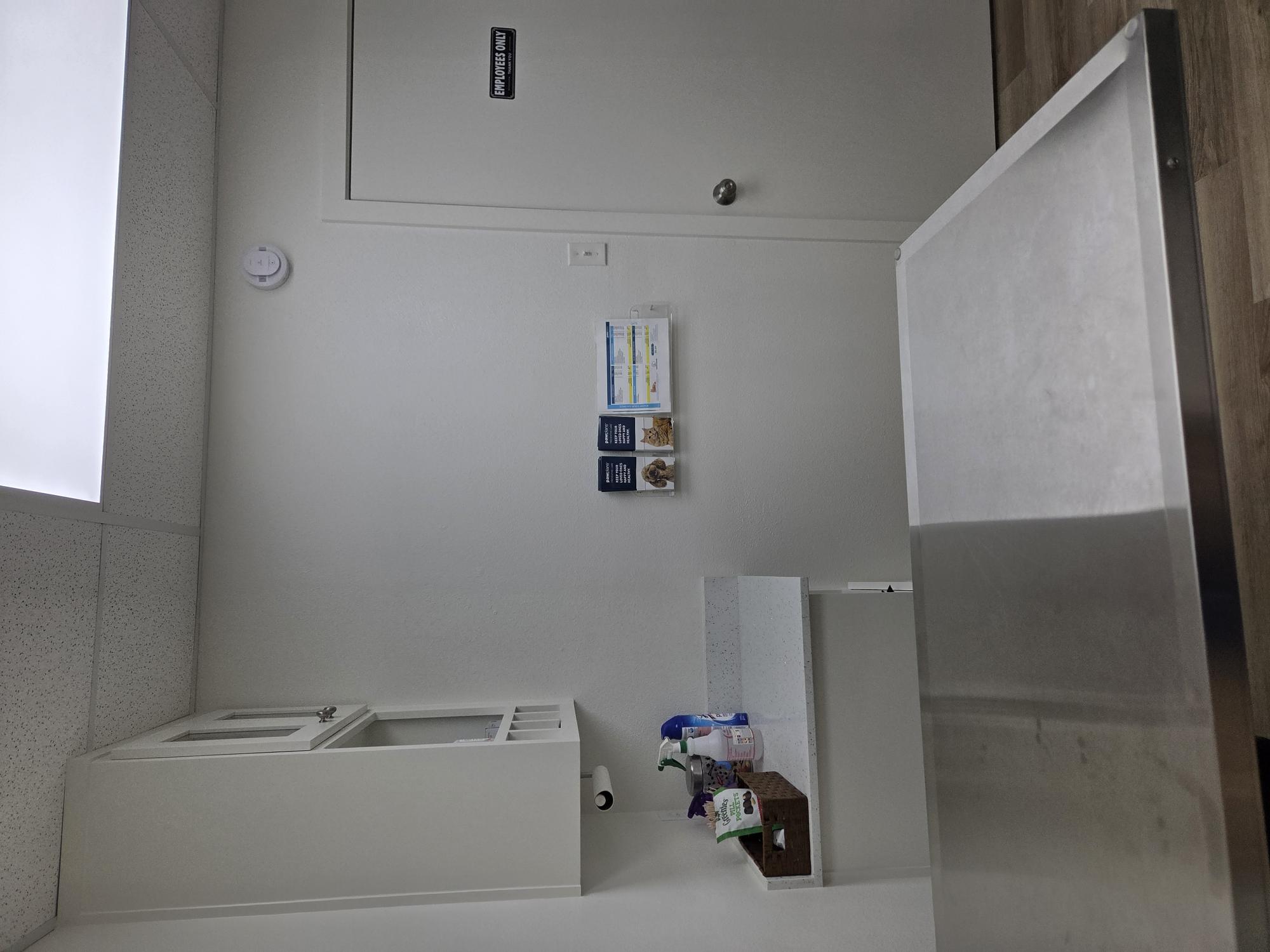 A white room with an examination bed and cabinet