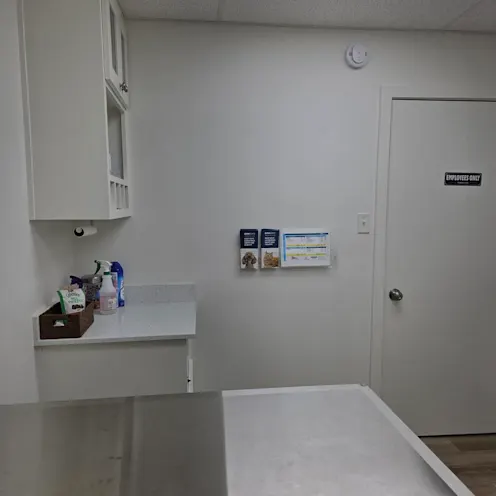 A white room with an examination bed and cabinet A white room with an examination bed and cabinet