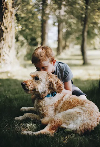 child with dog in grass