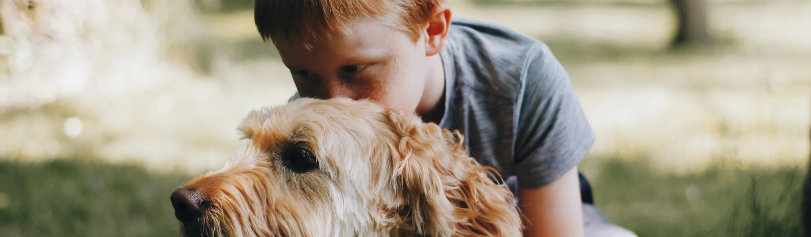 child with dog in grass