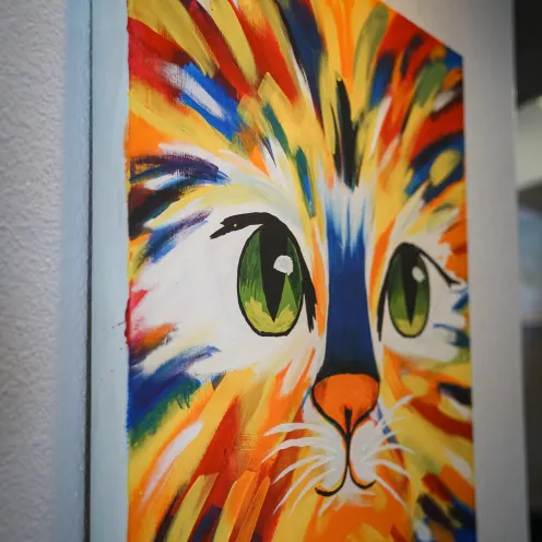 a colorful painting of a cat's face on the wall of the Great Oaks Animal Hospital lobby