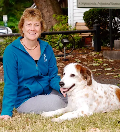 Beverly sitting on the grass with a dog next to her Beverly sitting on the grass with a dog next to her