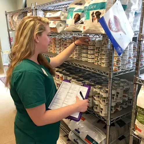 Employee counting inventory of cat food Employee counting inventory of cat food