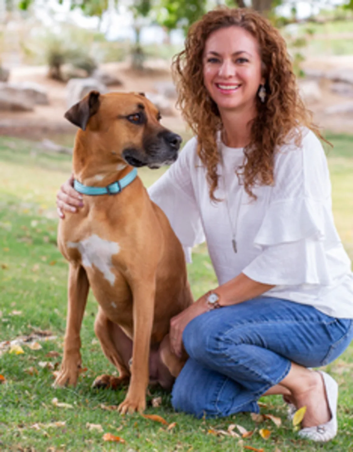 Brittney Carpenter kneeling next to a tan dog with a blue collar Brittney Carpenter kneeling next to a tan dog with a blue collar