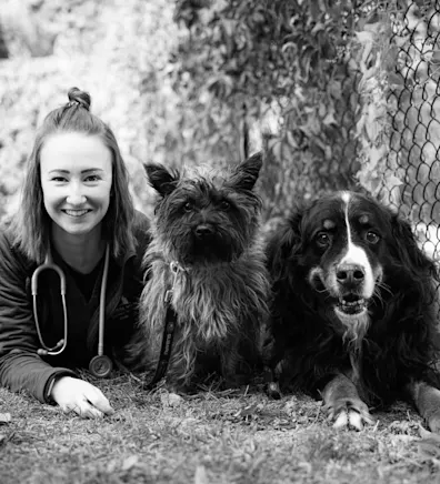 A photo of Emily laying with her two dogs A photo of Emily laying with her two dogs