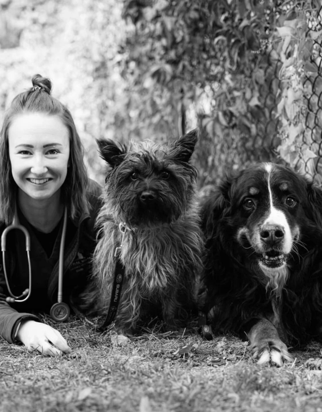 A photo of Emily laying with her two dogs A photo of Emily laying with her two dogs