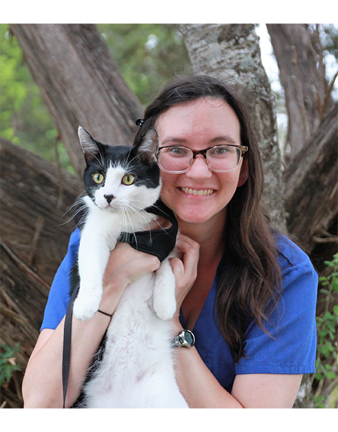 Cheryl smiling while holding a black and white cat