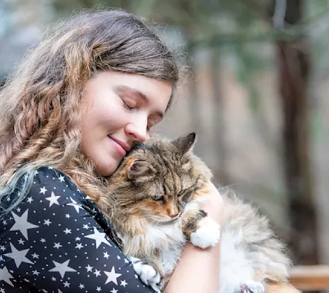 woman hugging cat