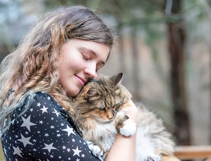 woman hugging cat